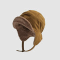 Mustard winter trapper hat with ribbed polyester shell, plush ear flaps, short brim and chin strap.