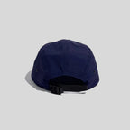Adjustable 5-panel cap in navy blue, rear view with an open back, panel seams and black webbing buckle
