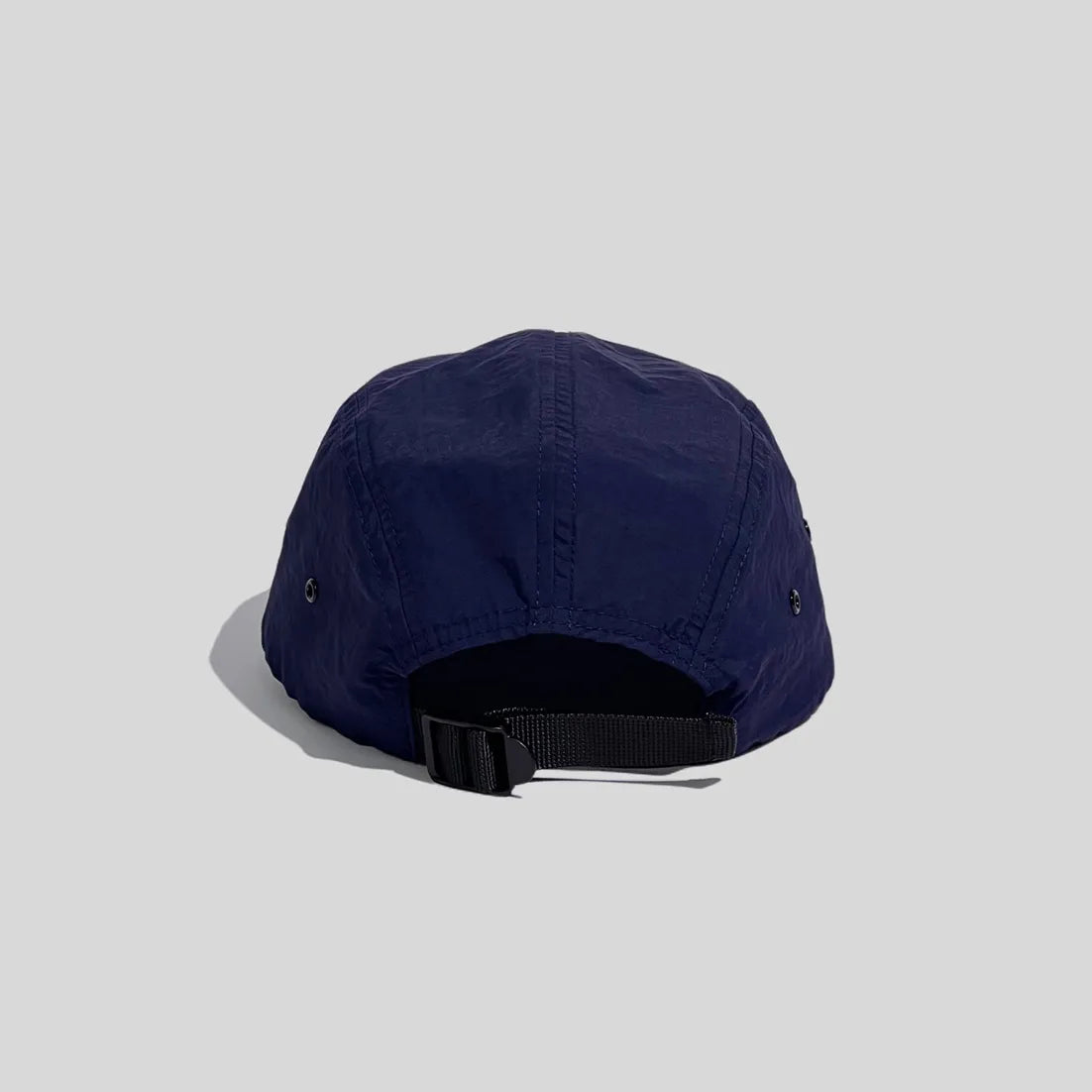 Adjustable 5-panel cap in navy blue, rear view with an open back, panel seams and black webbing buckle