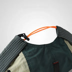 Adjustable docker cap detail in forest green and beige, showing the orange elastic drawcord, toggle and checked cuff