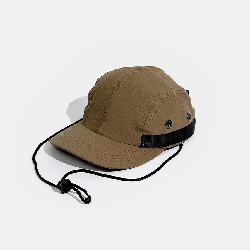 Adjustable hiking cap in tan, angled front view with a grid-textured crown, metal eyelets and toggle cord