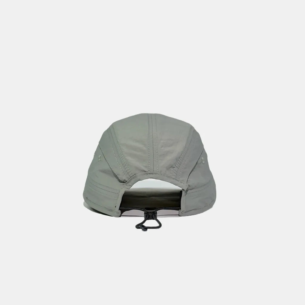 Adjustable nylon cap in light grey, rear view showing the open back, stitched panels and bungee toggle