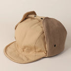 Close-up detail of beige ear flap trapper hat, corduroy side panels, stitched crown and curved short visor