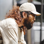 Man wearing a beige nylon baseball cap with a curved brim for a relaxed casual streetwear look