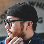 Side profile of a man wearing a black cotton corduroy skull cap with a low-profile brimless design