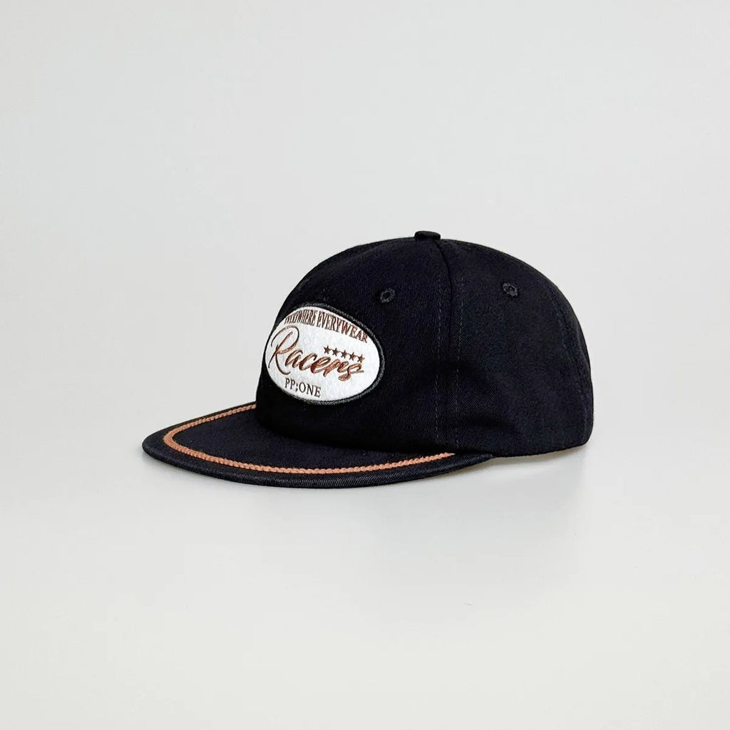 Angled view of a black baseball cap with a racing patch, contrast tan rope detail and a stitched flat brim.