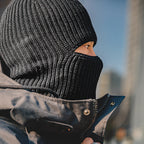 Side view of a black ribbed knit balaclava with a horizontal eye opening