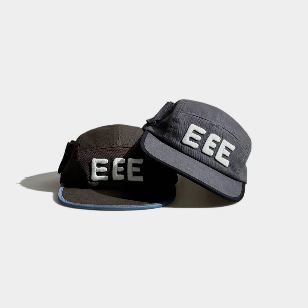 Brown and grey five-panel caps displayed together with raised white EEE embroidery, contrast brim trim and black side bow details.