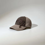Brown two-tone gothic baseball cap featuring dark embroidered lettering, stud details and a curved visor.