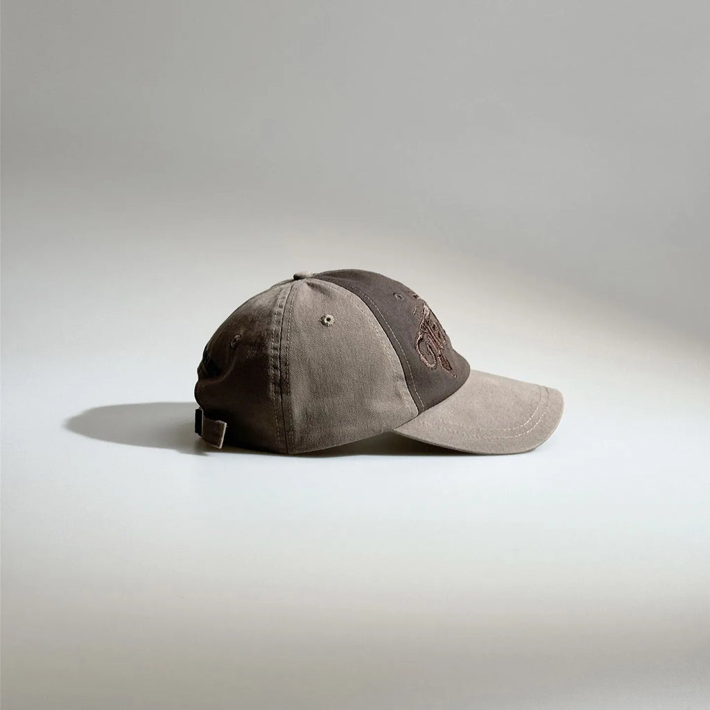 Side view of a brown vintage baseball cap showing the two-tone panels, curved brim and adjustable buckle closure.