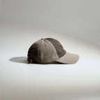 Side view of a brown vintage baseball cap showing the two-tone panels, curved brim and adjustable buckle closure.