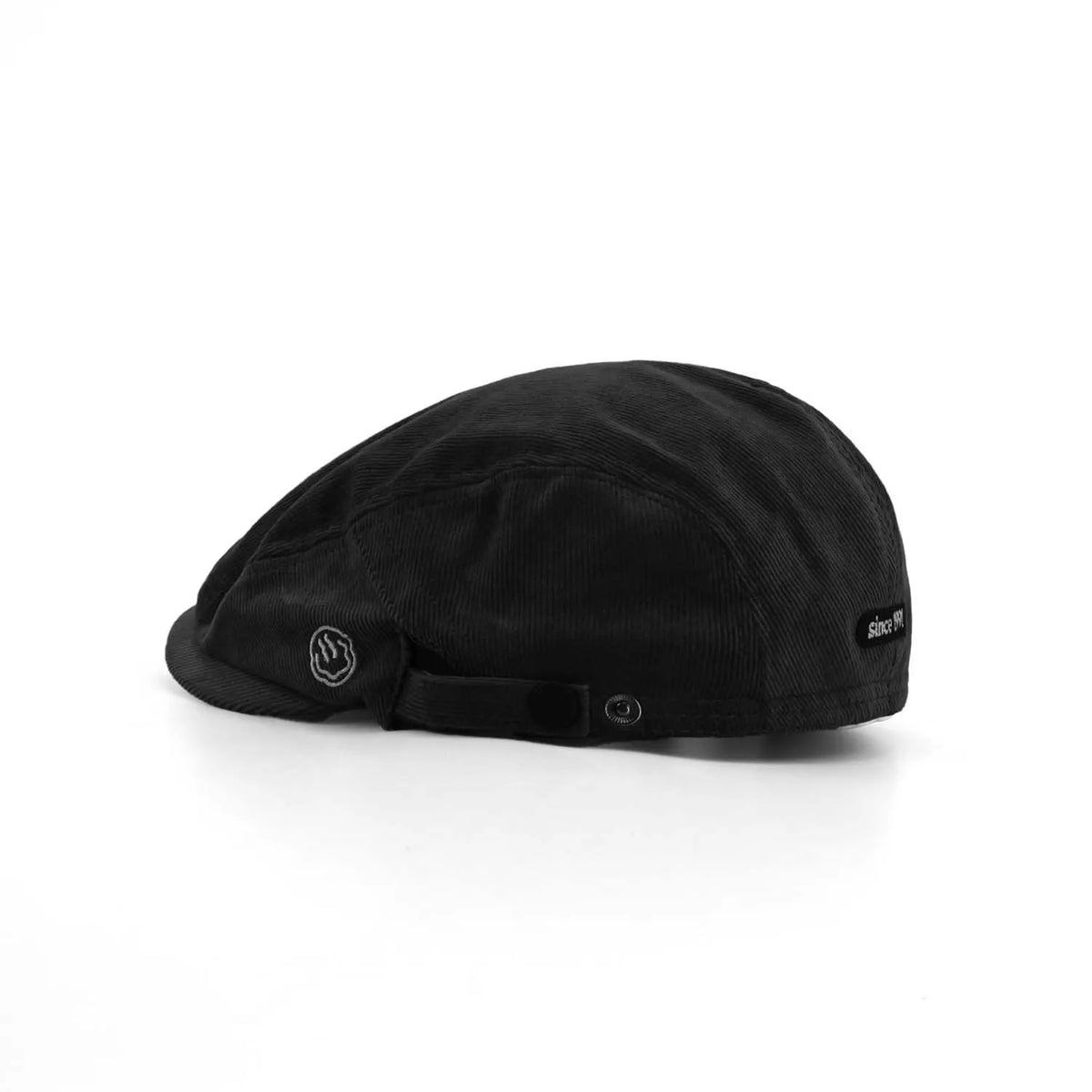 Cotton corduroy flat cap in black, side view with a short peak, smile embroidery and side snap adjuster
