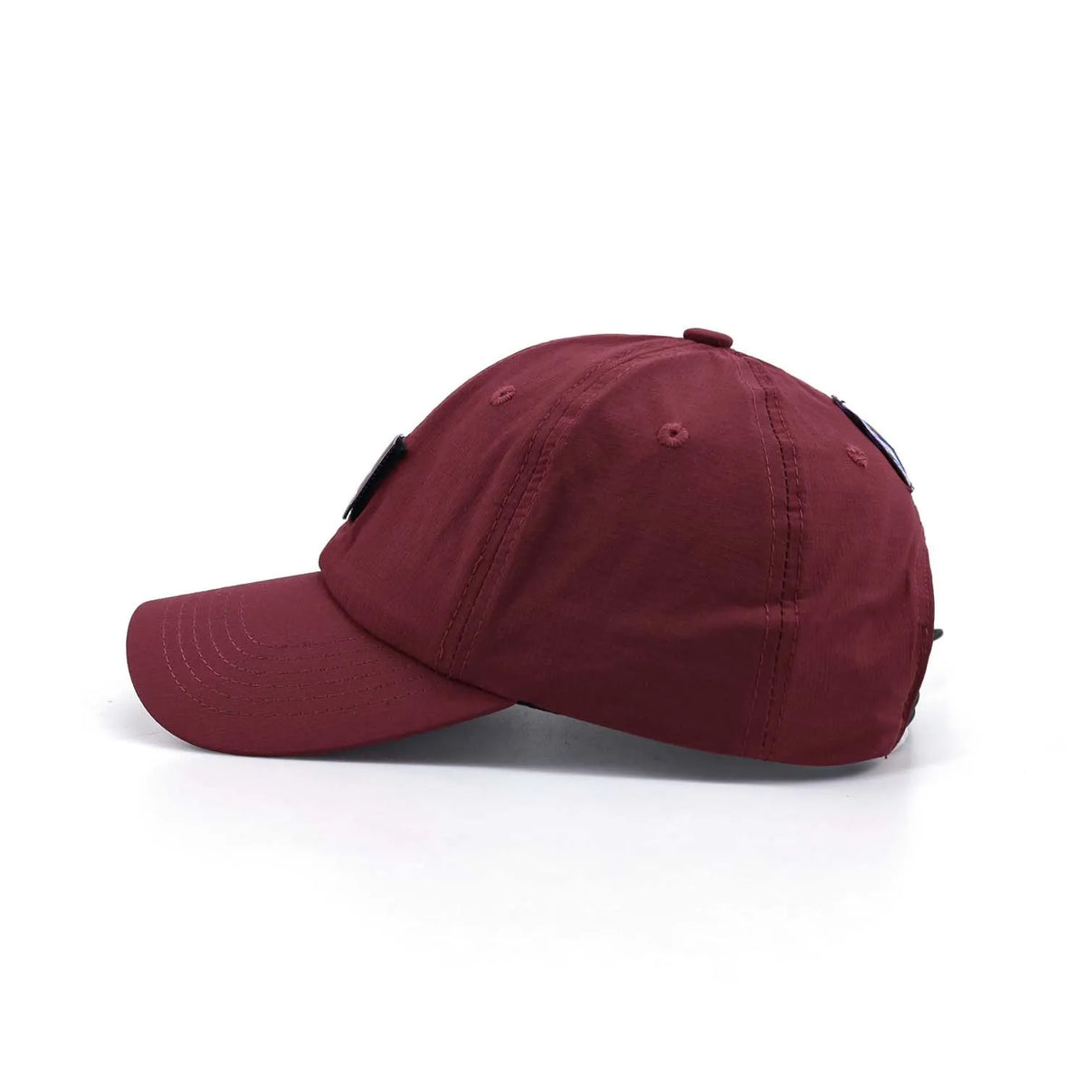 Curved peak baseball cap in burgundy, side profile with a relaxed crown, tonal stitching and small front label
