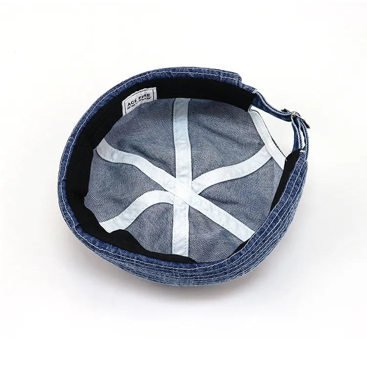Washed denim docker hat in indigo blue, inside view showing a black sweatband, light seam tapes and panelled crown