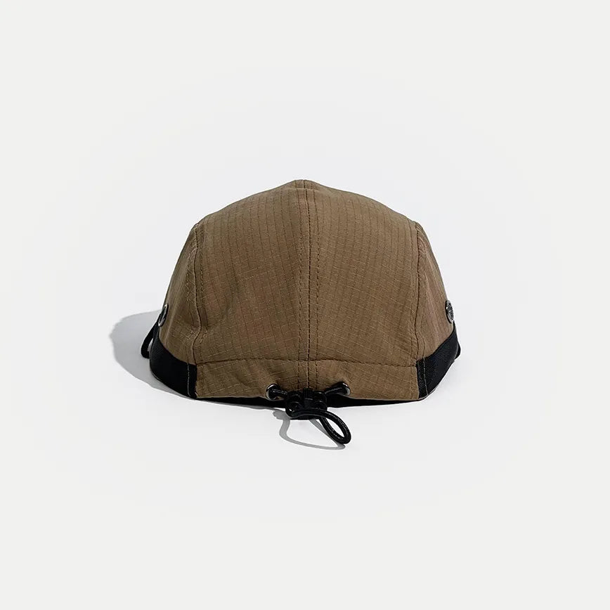 Drawcord outdoor cap in tan, rear view showing the elastic toggle adjuster, black side trim and panel stitching
