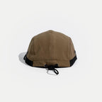 Drawcord outdoor cap in tan, rear view showing the elastic toggle adjuster, black side trim and panel stitching