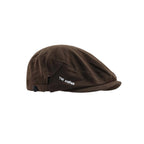 Duckbill flat cap in dark brown, side profile showing the close-fitting crown, short peak and letter embroidery