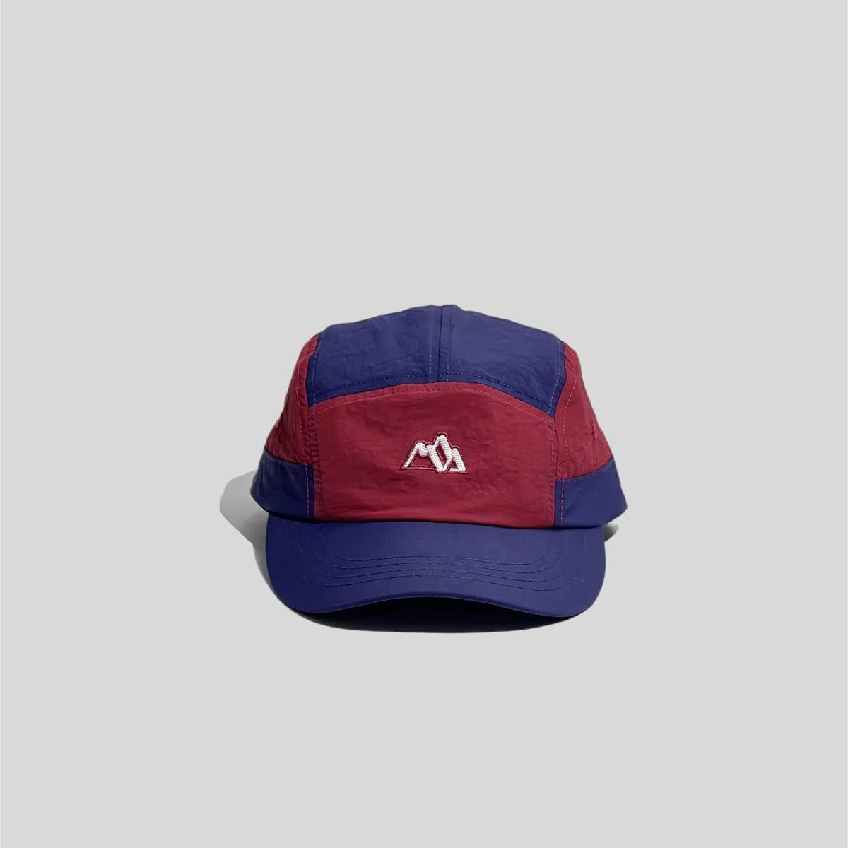 Embroidered five panel cap in navy and burgundy, front view with mountain logo and curved stitched brim