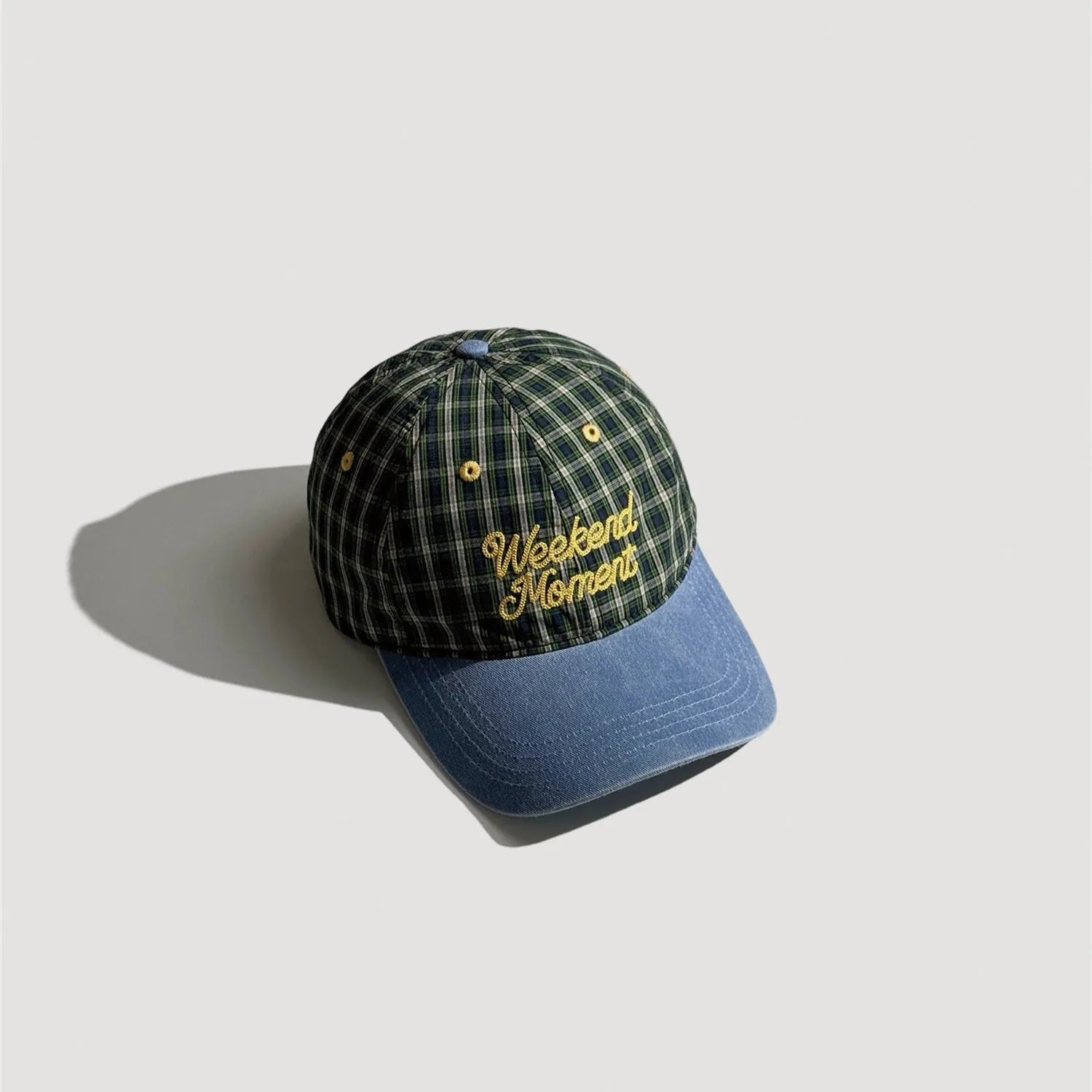 Embroidered plaid outdoor cap featuring retro lettering and detailed fabric pattern