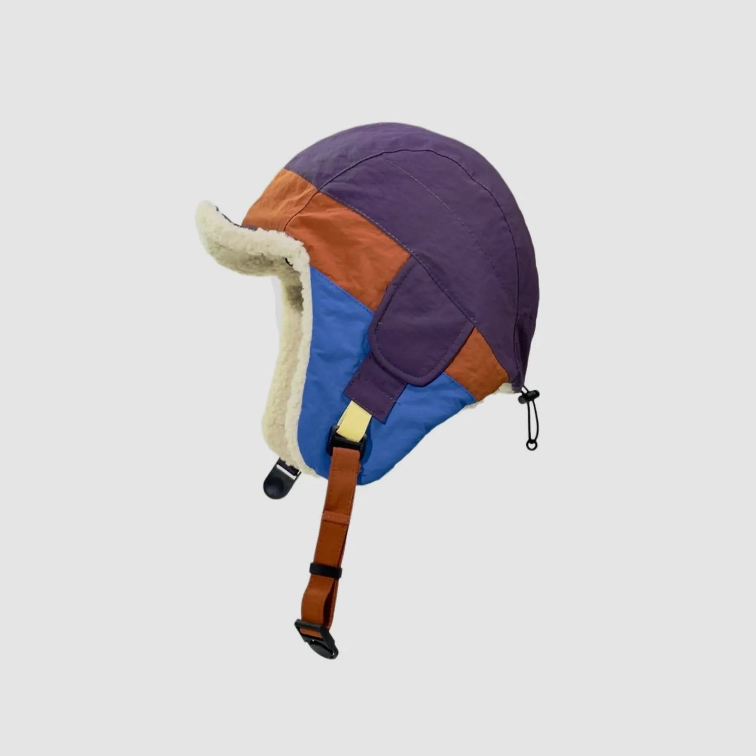 Purple and orange fleece-lined winter cap side view with blue panel, ear cover and adjustable buckle strap.