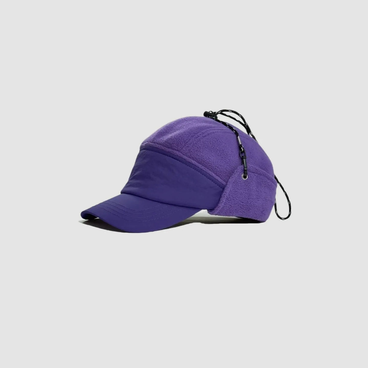 Purple fleece winter cap at a three-quarter angle with curved brim, side ear panel and adjustable top cord.