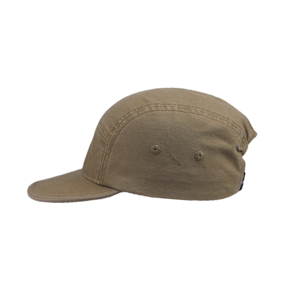Side view of a khaki cotton 5 panel cap showing the curved brim, stitched crown panels and two side eyelets