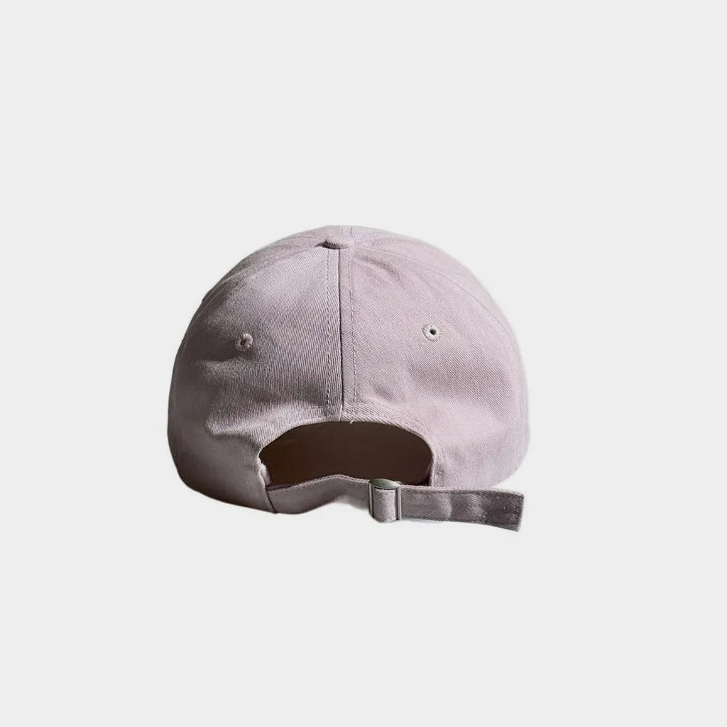 Back view of a light pink baseball cap with an open back and adjustable fabric strap with a metal buckle.