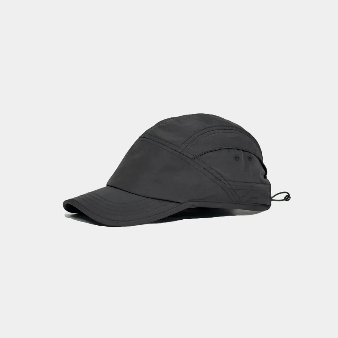 Lightweight nylon sports cap in black, angled view showing the low-profile crown and tonal panel stitching
