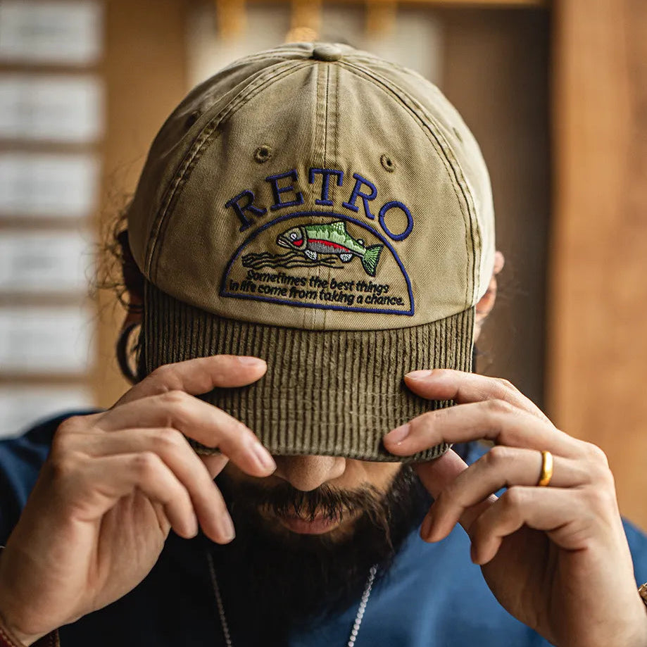 Man wearing a khaki retro fish embroidered baseball cap with a contrasting corduroy curved brim