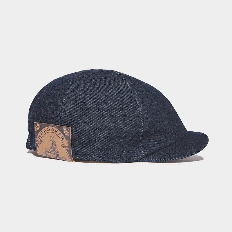 Dark indigo denim flat cap with vintage short brim design and classic workwear style
