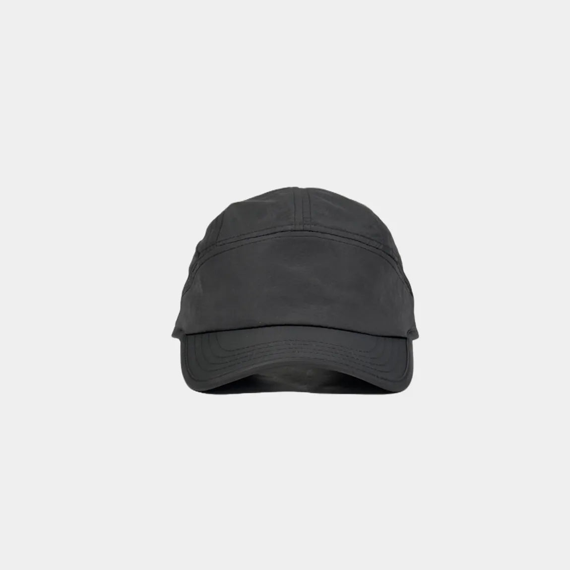 Minimalist nylon baseball cap in black, front view with a plain crown and curved multi-row stitched brim