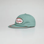 Angled view of a mint green rope cap with a racing patch, six-panel crown and contrast red brim trim.