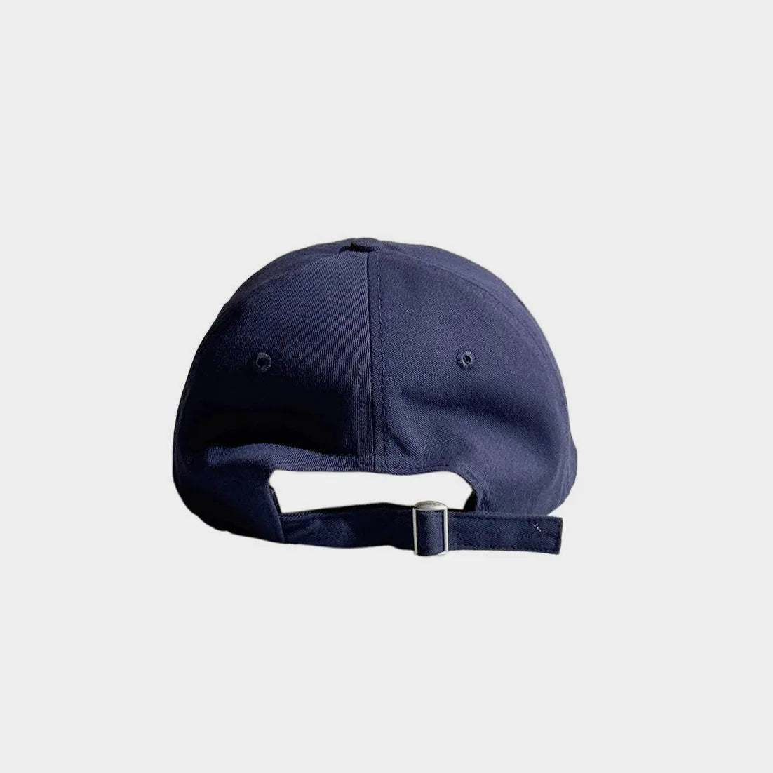 Back view of a navy baseball cap with an open back and adjustable fabric strap with a metal buckle.