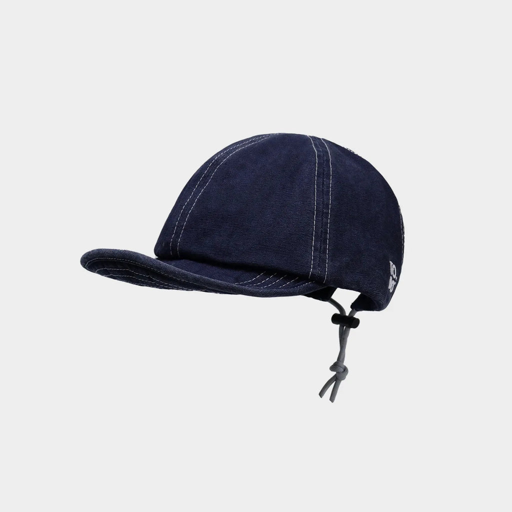 Low-angle view of a navy cotton cap featuring visible contrast stitching and a short curved brim