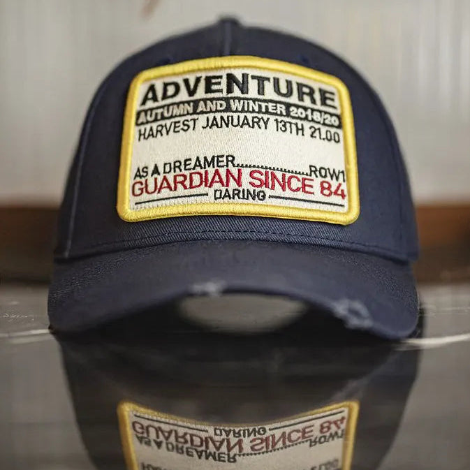 Front view of a navy cotton baseball cap with an Adventure patch and curved brim