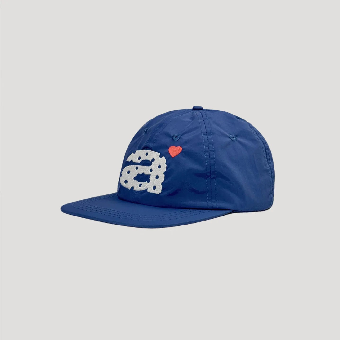Navy flat brim nylon cap side profile showing low crown construction