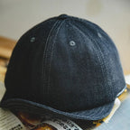 Indigo six-panel denim baseball cap with tonal eyelets, curved brim and visible twill texture