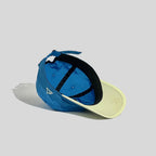 Nylon baseball cap in blue and pale yellow, interior view showing the black sweatband and taped crown seams