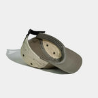 Nylon camper cap interior in olive grey, khaki and cream, showing the sweatband, bound seams and eyelets