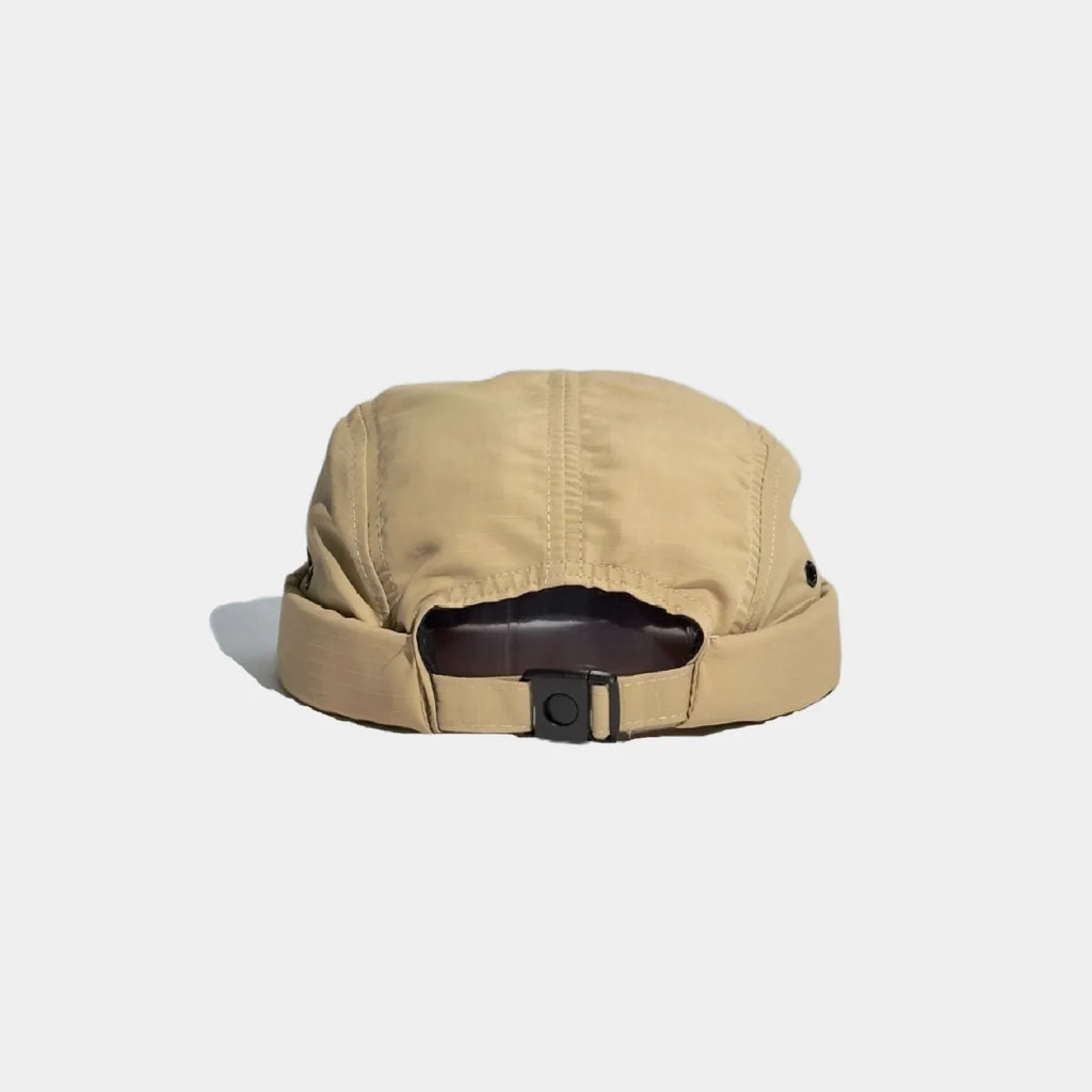 Nylon docker cap in khaki, seen from the back with a matching adjustment strap, black buckle and curved opening.