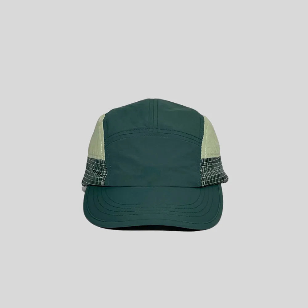 Nylon five panel cap in forest green and cream, front view with a curved stitched peak and fine grid side panels