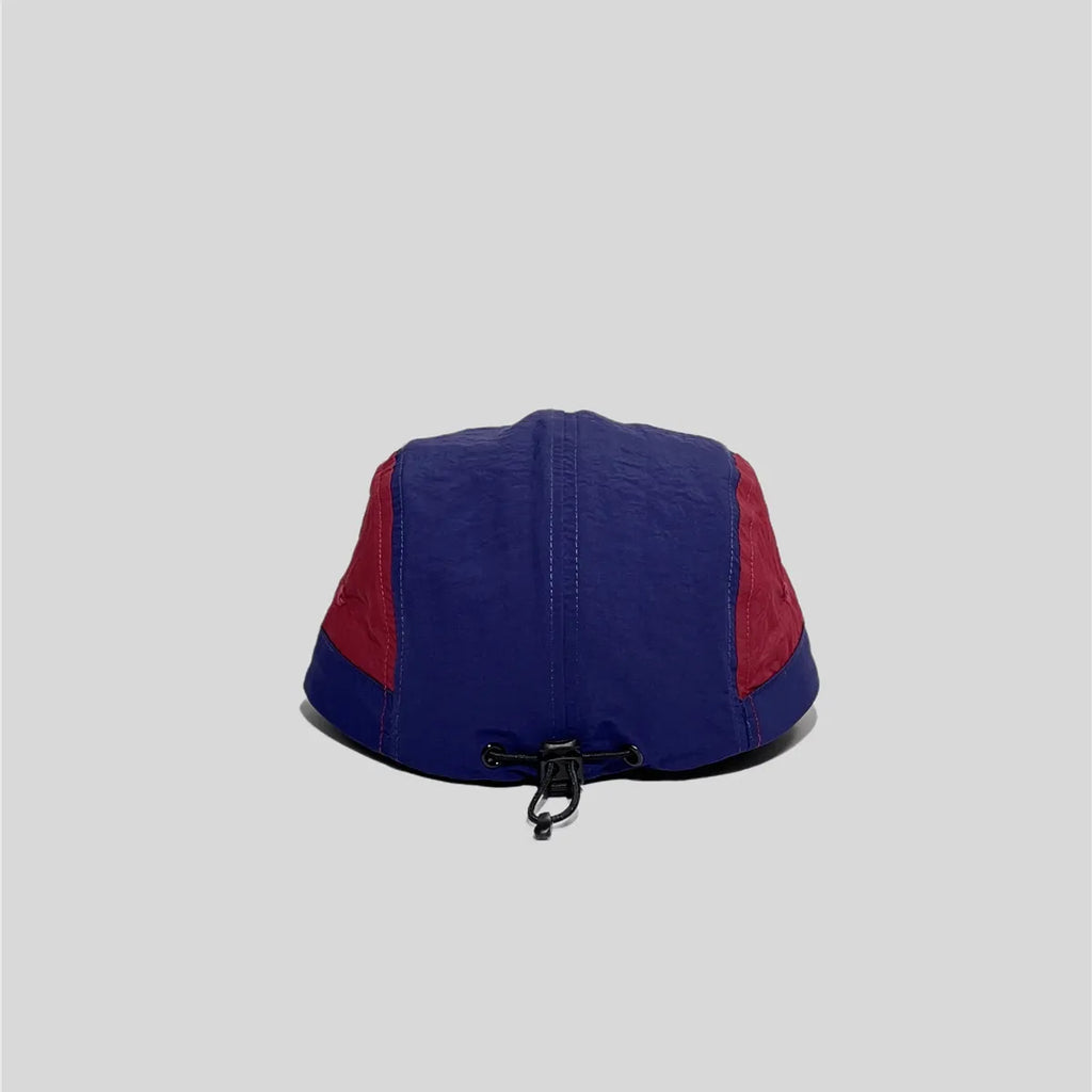 Nylon five panel cap in navy and burgundy, rear view showing the black bungee toggle and panel stitching