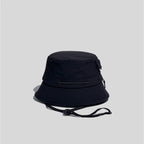 Nylon outdoor bucket hat in black, cord-side view showing the adjustable crown cord and multi-row brim stitching