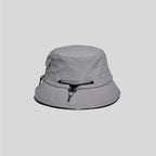 Nylon outdoor bucket hat in light grey, cord-side view showing the adjustable crown cord and multi-row brim stitching
