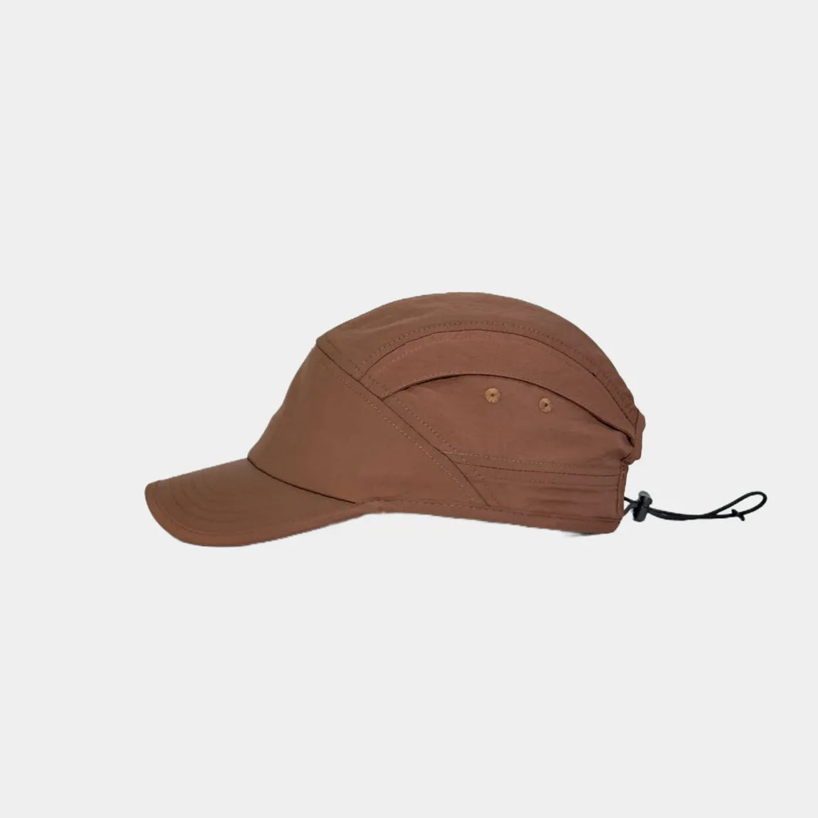 Nylon outdoor cap in rust brown, side view showing two eyelets, curved seams and rear drawcord adjuster