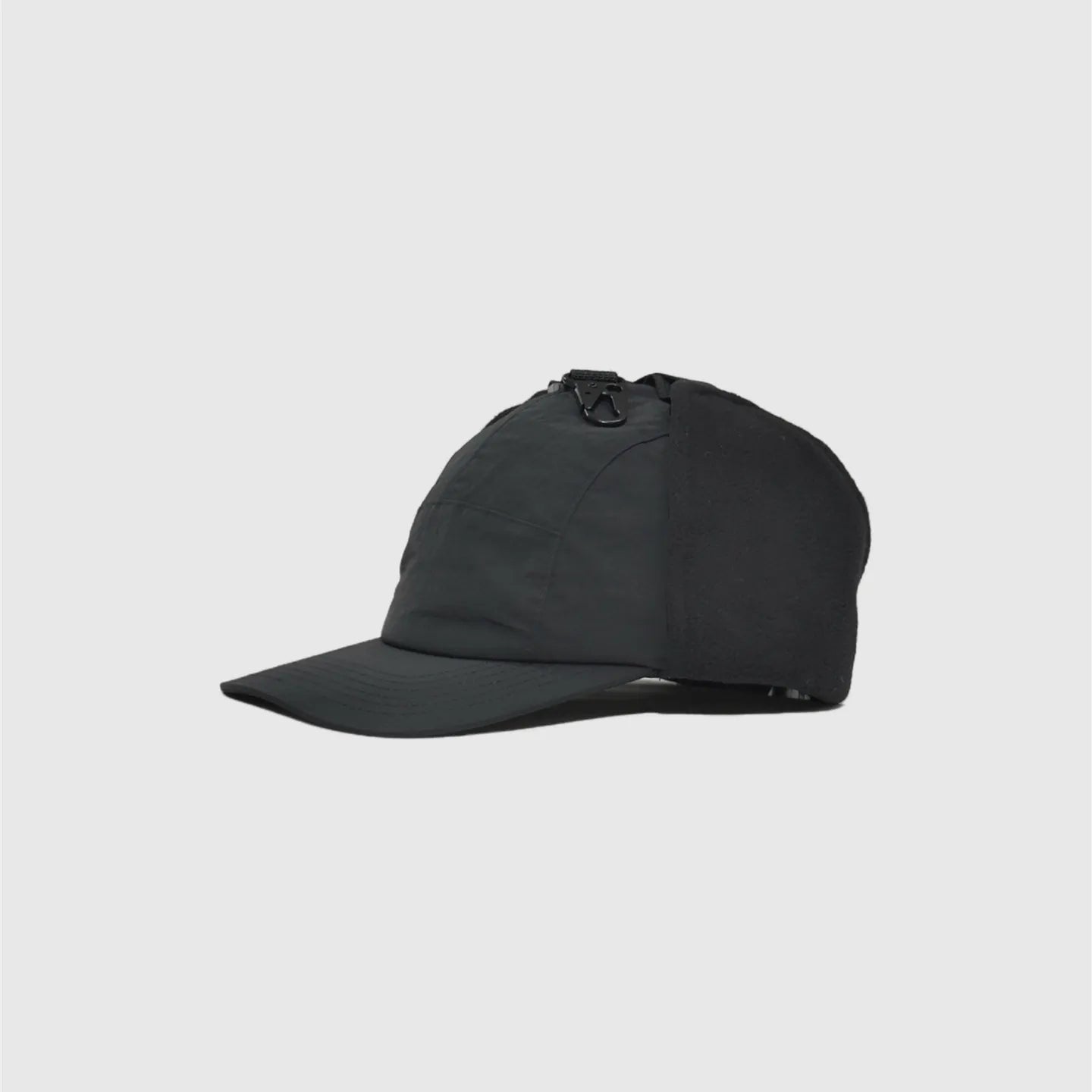 black winter baseball cap side view with folded fleece ear panel, curved peak and smooth nylon crown.