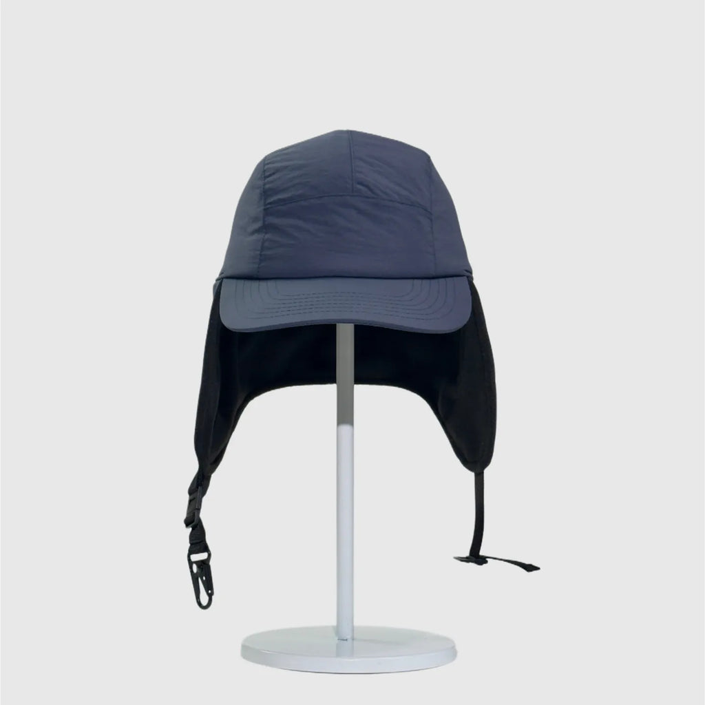 Navy nylon winter ear flap cap front view with extended side covers, stitched brim and buckle straps.
