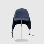 Navy nylon winter ear flap cap front view with extended side covers, stitched brim and buckle straps.
