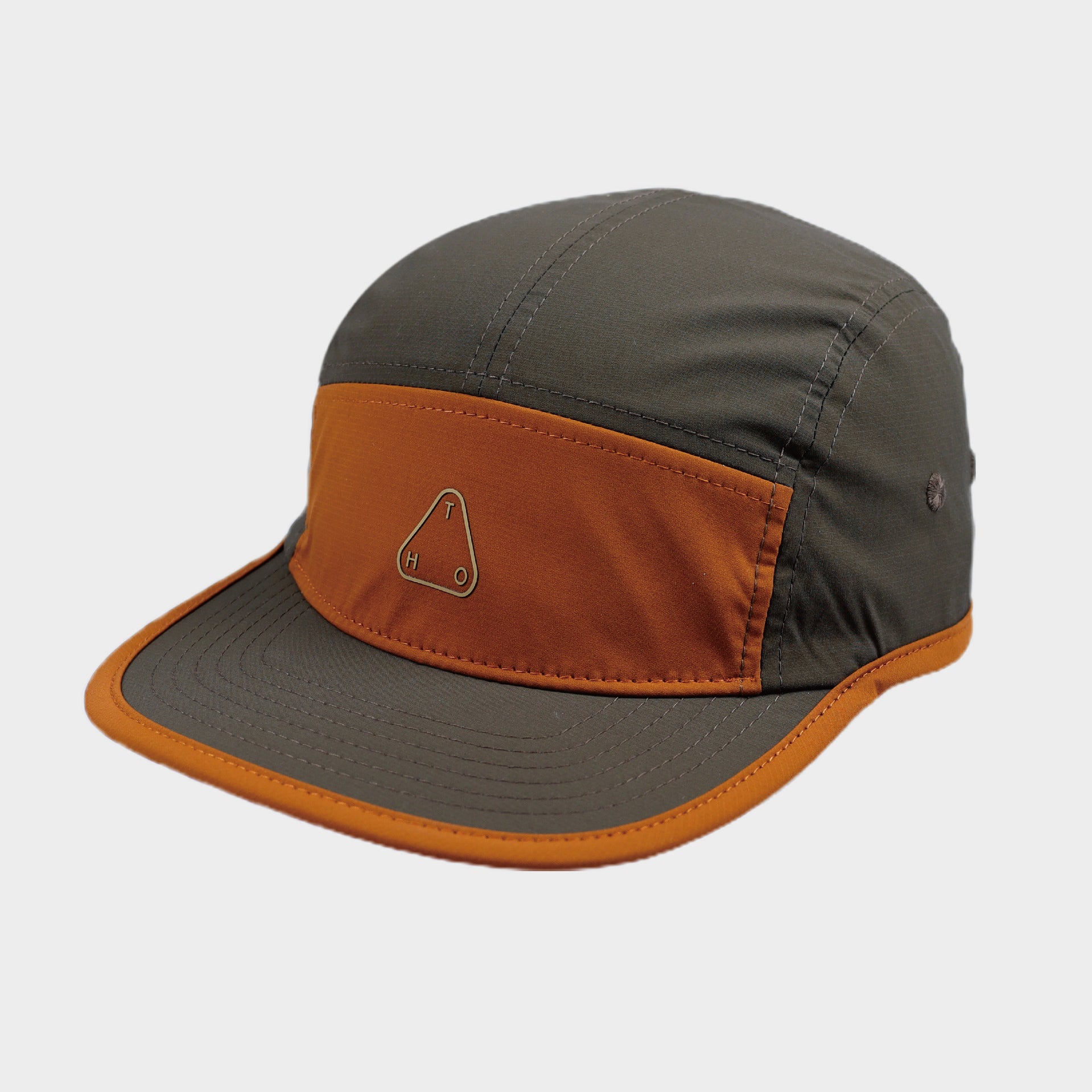 Olive brown five-panel cap with an orange front panel and brim edging, visible top stitching and minimalist logo.
