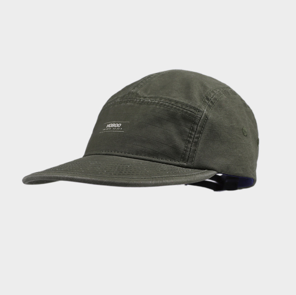 Olive green cotton 5 panel cap with a small front logo, stitched panel construction, curved brim and side eyelet